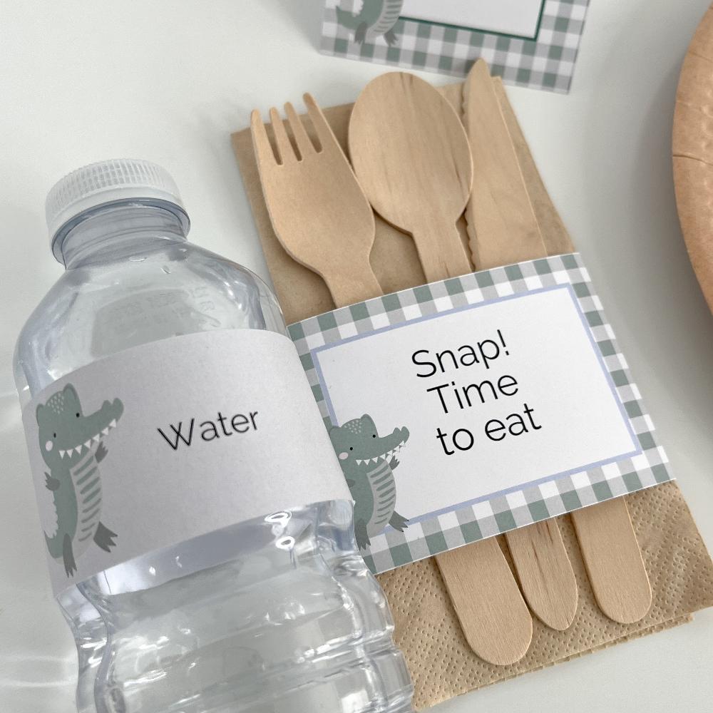 Crocodile themed party decorations on a water bottle and other tableware